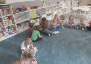Dzieci słuchające książki czytanej przez jedną z mam
