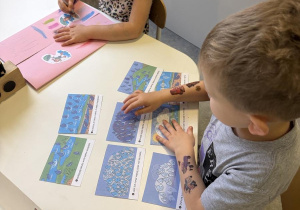 dzieci wykonują lapbook o jesiennej pogodzie