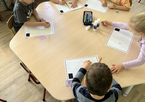 Dzieci podczas wykonywania własnej pocztówki przy stolikach