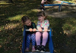 Dziewczynki na bujaku w ogrodzie przedszkolnym