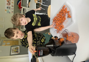 dzieci robią sok marchewkowy w wyciskarce wolnoobrotowej