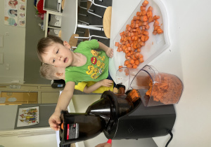 dzieci robią sok marchewkowy w wyciskarce wolnoobrotowej
