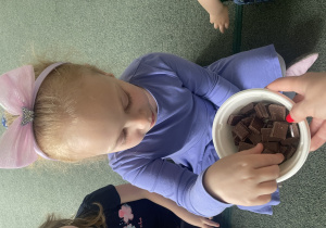 dzieci częstują się kostką czekolady