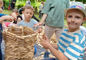 Chłopcy prezentują budowlę z drewnianych klocków
