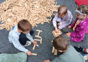 Dzieci podczas budowania z drewnianych klocków