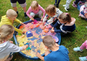 Dzieci podczas zabawy sensorycznej kolorową masą plastyczną