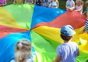 Dzieci podczas zabawy z piłkami w kole.