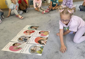 Dzieci na dywanie omawiają karty z "Kodeksem Przedszkolaka".