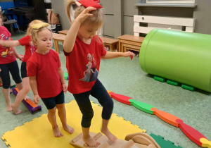 Dziewczynka przechodzi po ruchomej kładce. Pozostałe dzieci czekają na swoją kolej