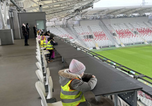 Dzieci siedzące na trybunach stadionu