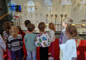 dzieci przygladają się maskom teatralnym