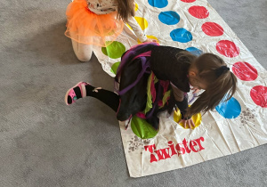 Dziewczynki grające na dywanie w grę Twister