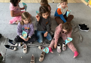 Dzieci na dywanie jedzące popcorn