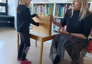 Dziewczynka otwiera Teatrzyk Kamishibai
