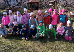 Dzieci pozują do zdjęcia w ogrodzie przedszkolnym