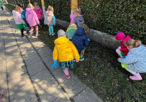 Dzieci zbierają śmieci na jednej z osiedlowych uliczek
