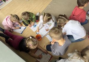 dzieci w bibliotece kolorują obrazki na podłodze