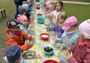 dzieci podczas warsztatów botanicznych wykonują las w słoiku