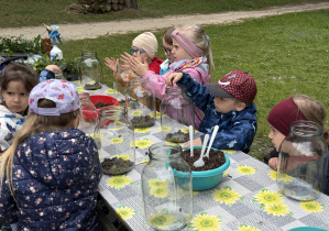 dzieci podczas warsztatów botanicznych wykonują las w słoiku