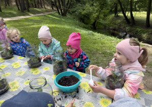 dzieci podczas warsztatów botanicznych wykonują las w słoiku