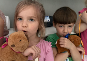 dzieci z pluszowymi kapibarami, prezentem na Dzień Dziecka