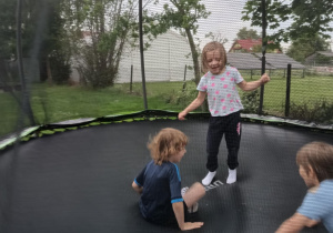 Dzieci skaczą na trampolinie