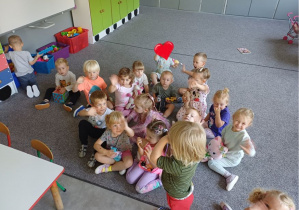 dzieci siedzą na dywanie