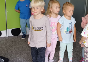 dzieci stoją na dywanie