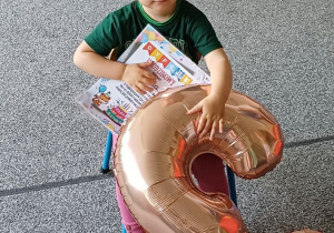 dziewczynka siedzi na tronie urodzinowym