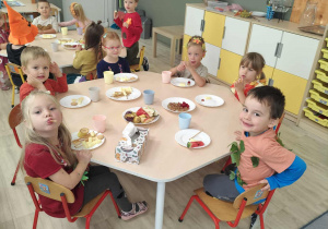 Dzieci przy stoliku podczas poczęstunku z okazji Balu Jesieni