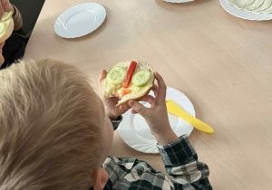 Dzieci podczas spożywania kanapek, które samodzielnie przygotowali