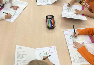 Dzieci podczas pracy w książce przy stolikach