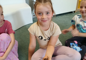 Dziewczynka trzyma na ręku wylinkę pająka ptasznika