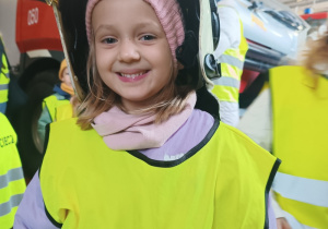 Dziewczynka przymierzająca hełm strażacki