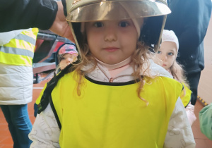 Dziewczynka przymierzająca hełm strażacki
