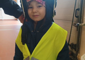 Dziewczynka przymierzająca hełm strażacki