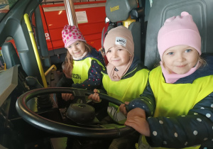 Dzieci siedzące w wozie strażackim