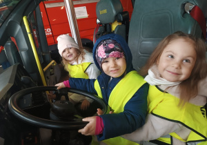 Dzieci siedzące w wozie strażackim