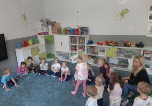 Dzieci słuchające książki czytanej przez jedną z mam