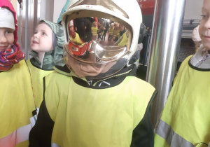 Dziewczynka przymierzająca hełm strażacki