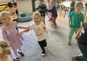 Dzieci podczas zabaw ruchowych na dywanie