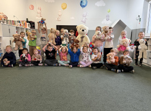 dzieci pozują z misiami na Dzień Pluszowego Misia