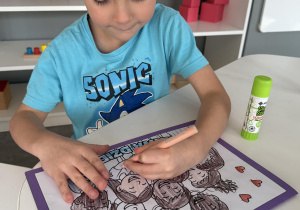 dzieci wyklejają i kolorują książeczkę o prawach dziecka