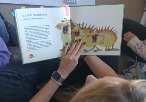 Pani bibliotekarka czyta dzieciom o Siostrach Słodyczkach