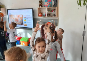 Dzieci podają sobie dynię nad głowami