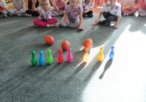 Dzieci zbijają kręgle za pomocą dyń