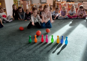 Dziewczynki zbijają kręgle za pomocą dyń