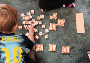 Dzieci konstruują z klocków małe litery pisane "a"