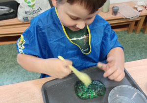 Chłopiec tworzy masę sensoryczną
