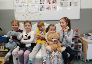 Dzieci pozują do zdjęcia ze swoimi pluszowymi misiami